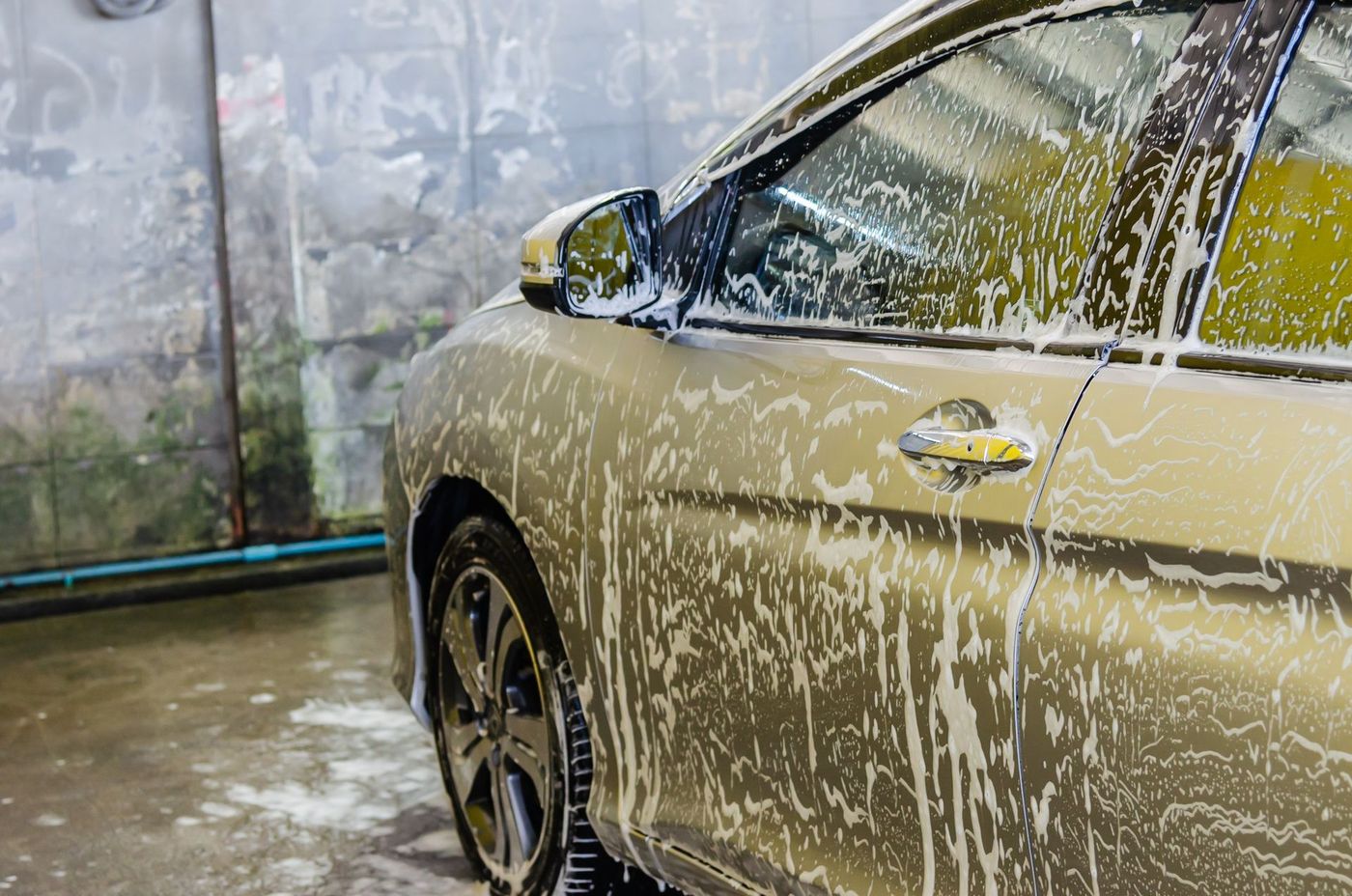 A car covered in wash foam during an exterior clean