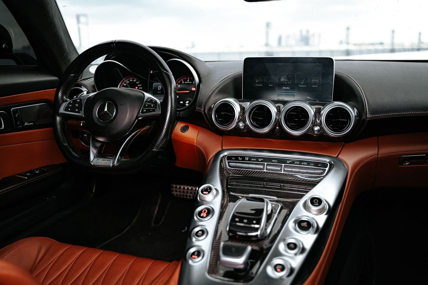A car interior with a clean dashboard, screen and leather seats